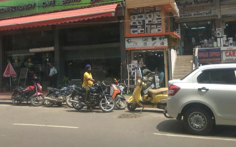 Shops and parked two-wheelers along Exhibition Road, Patna